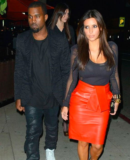 Ким Кардашьян в черной блузке и красной юбке с Кани Уэстом